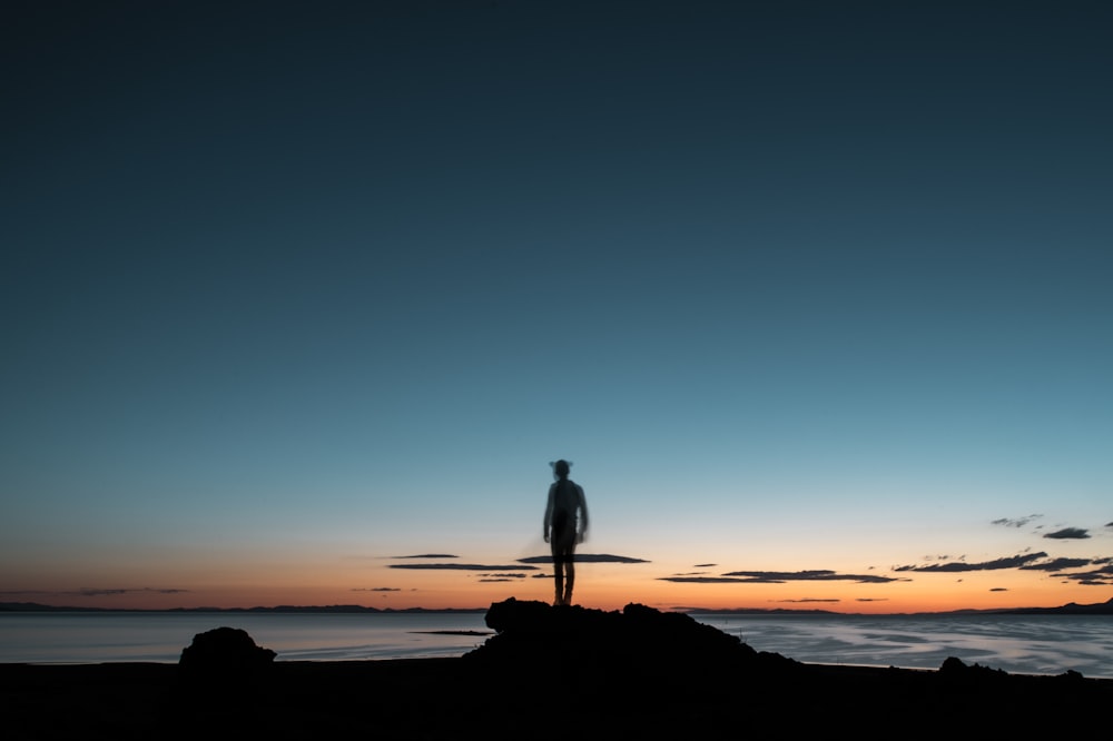 sillhouette of a man facing the beach