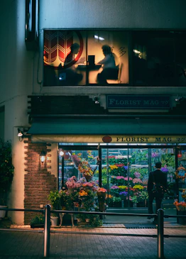 man standing on store front during nighttime