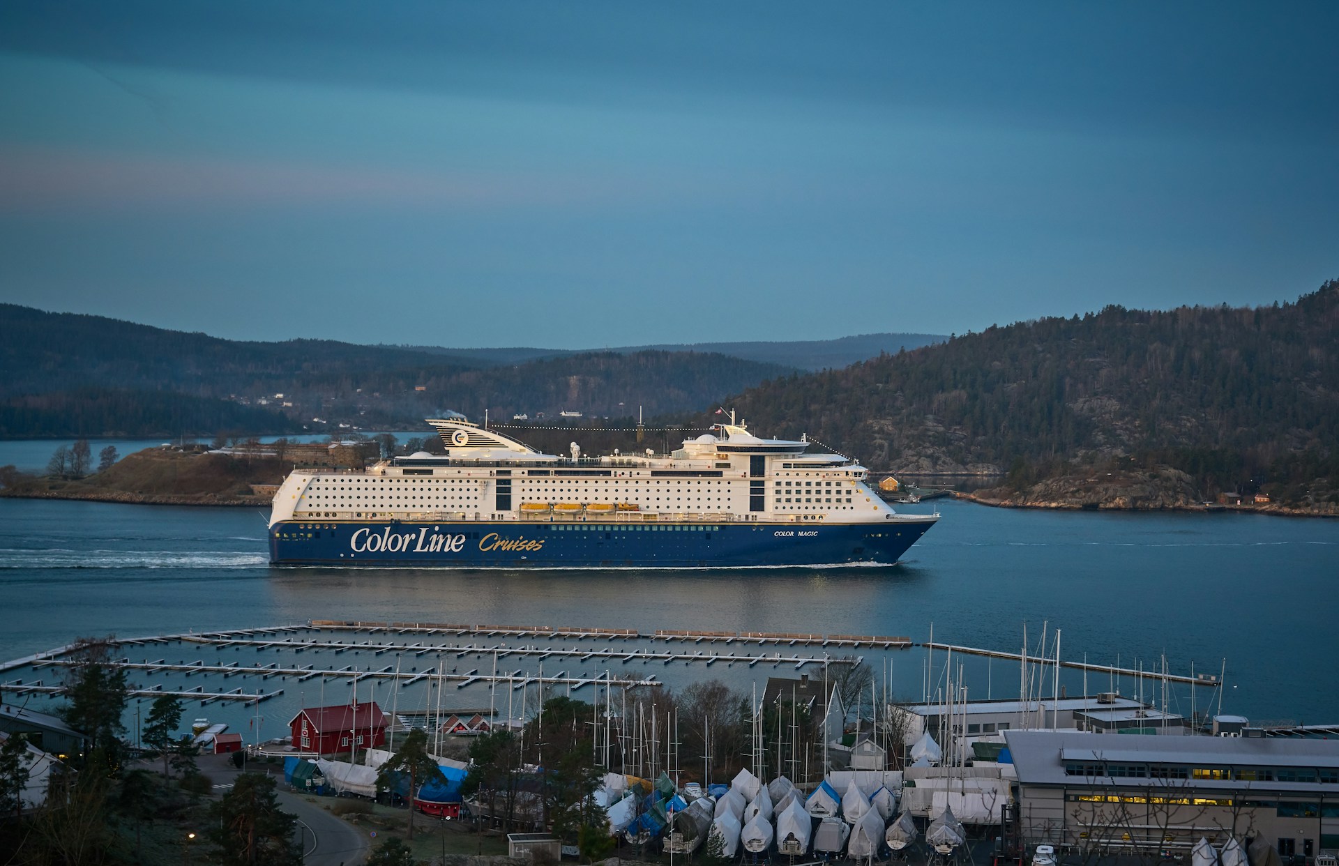 blue and white cruise ship passing channel