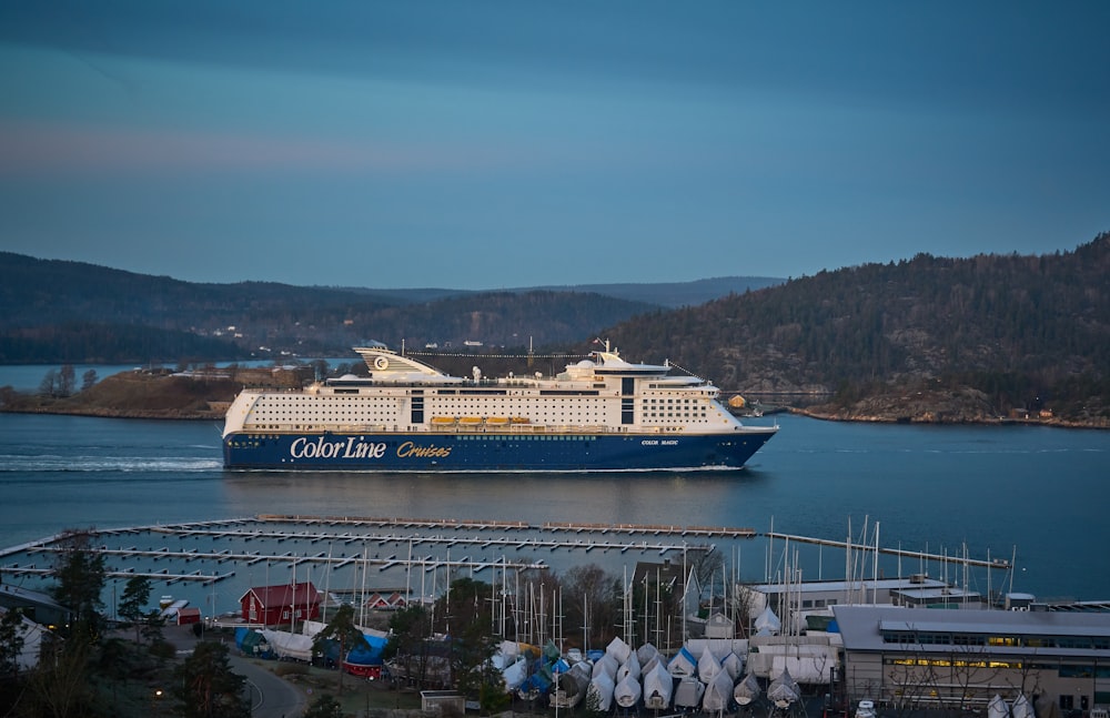 blue and white cruise ship passing channel