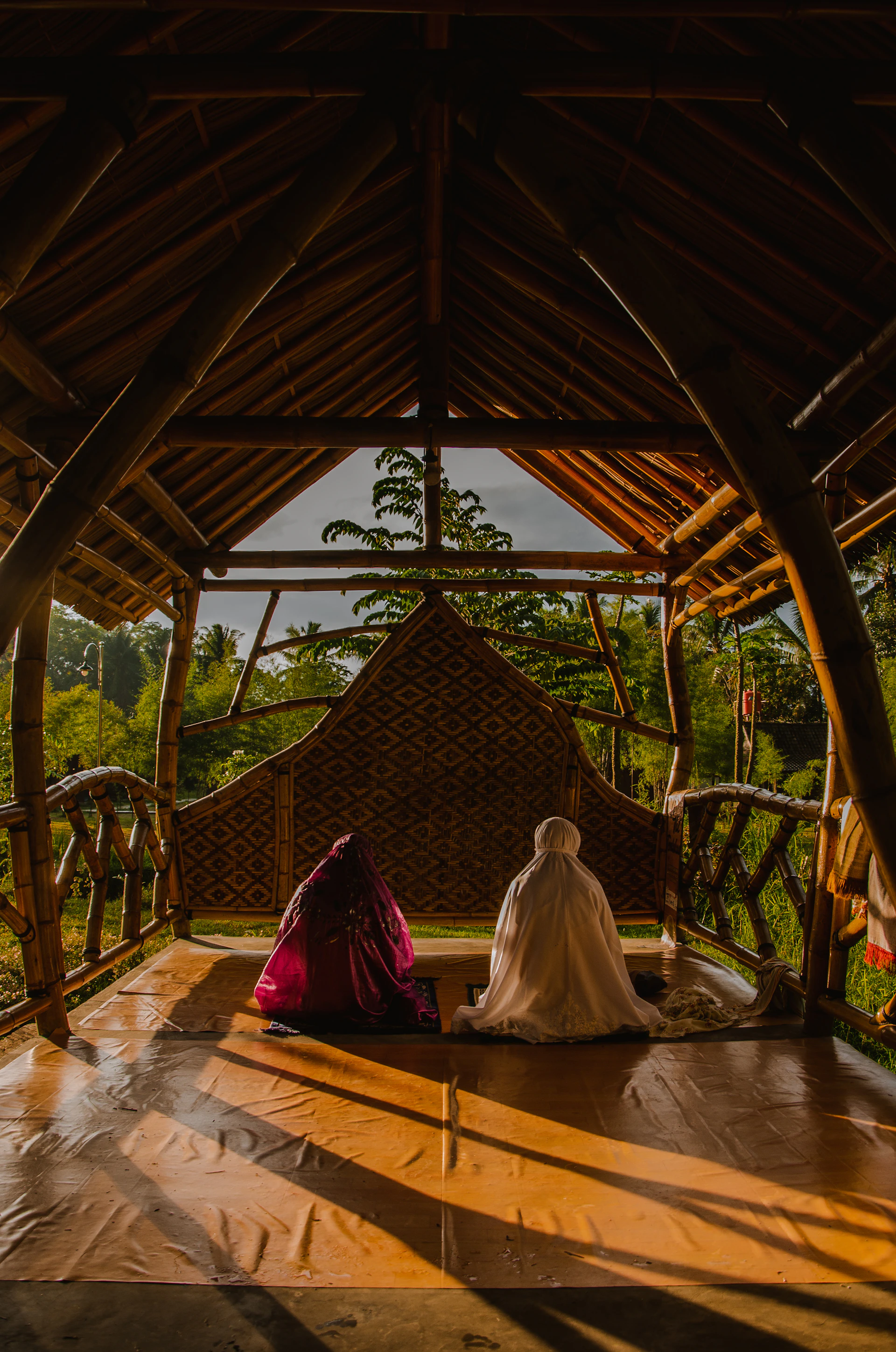 Meditators sitting peacefully in a traditional wooden hall at Sativana, bathed in soft natural light.