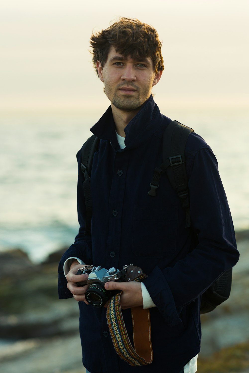 man wearing black jacket holding DSLR camera