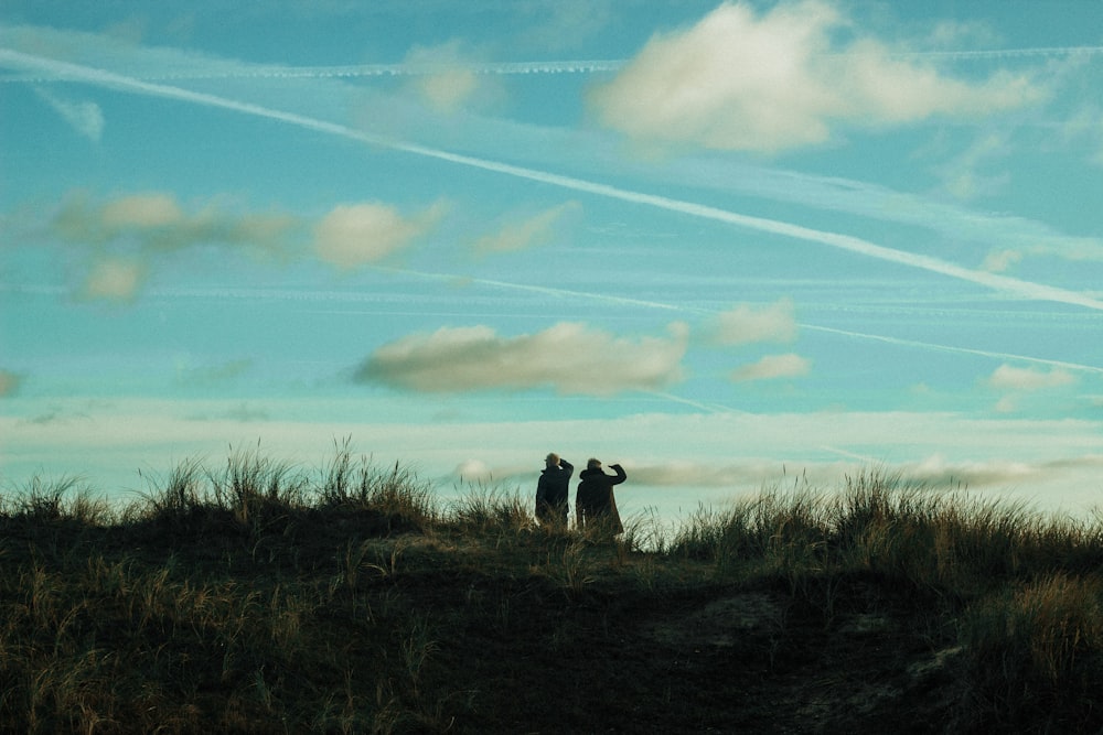 two person standing on grass field