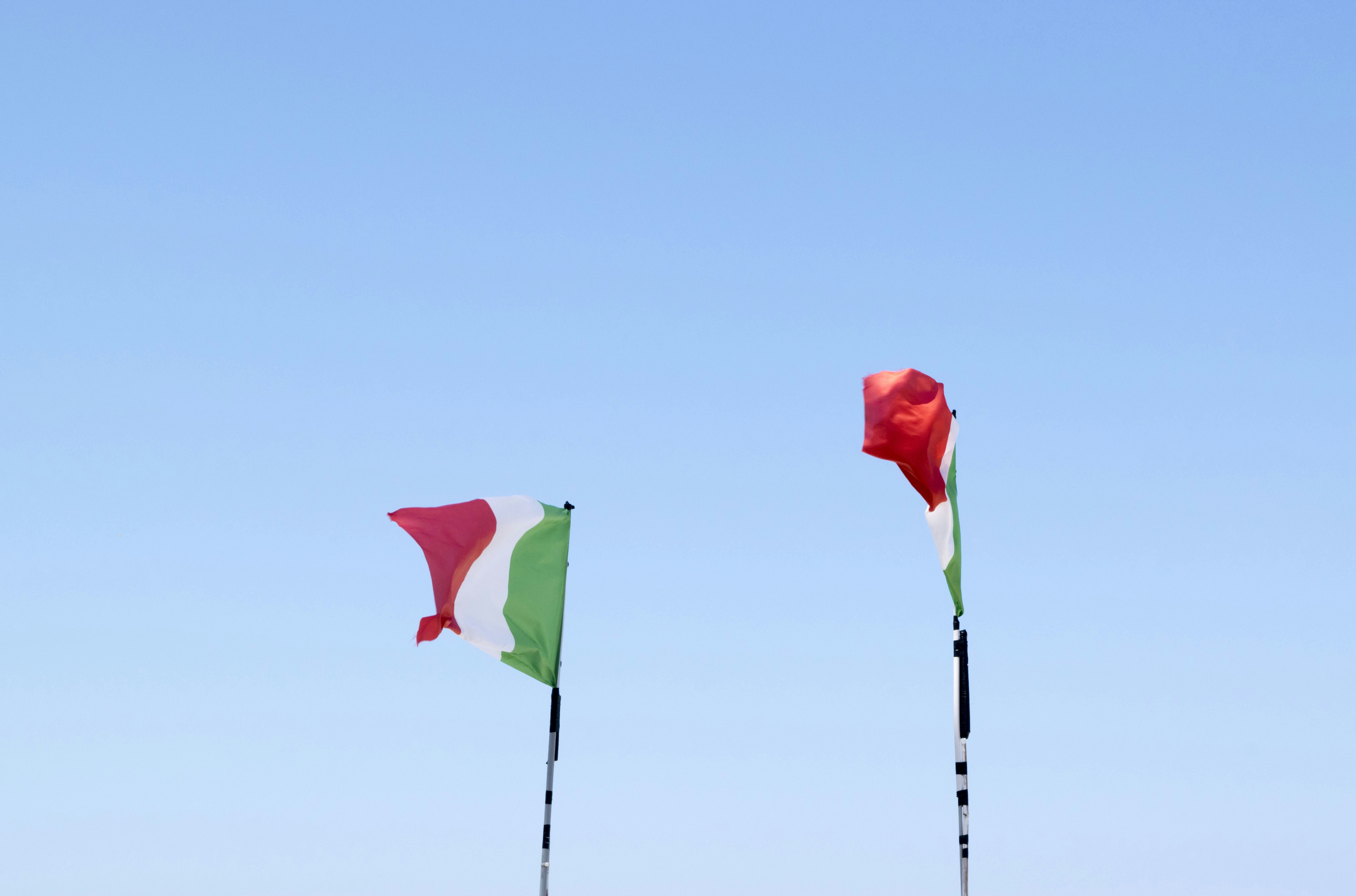 two flags of Italy on flag poles