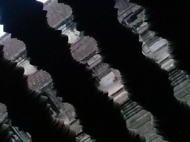 Dimly lit ancient temple interior with subtle mystical symbols blending Guarani and Egyptian motifs on dark stone walls.