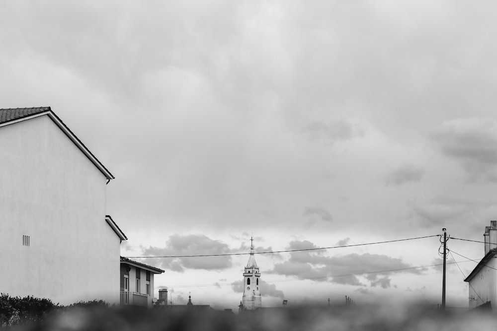 grayscale photo of houses under cloudy sky