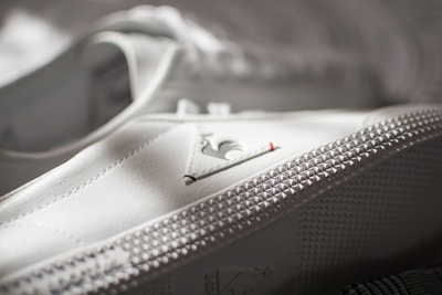 Detailed view of a sneaker showing added studs and hand-stitched accents.
