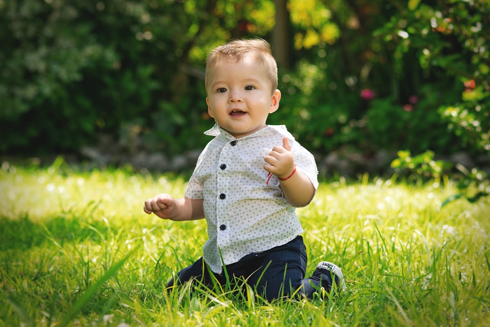 baby kneeling on grass