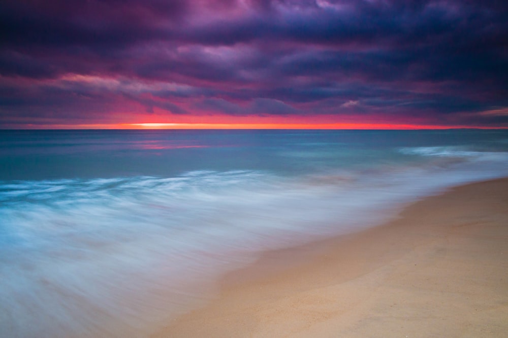 landscape photo of ocean under cloudy sky