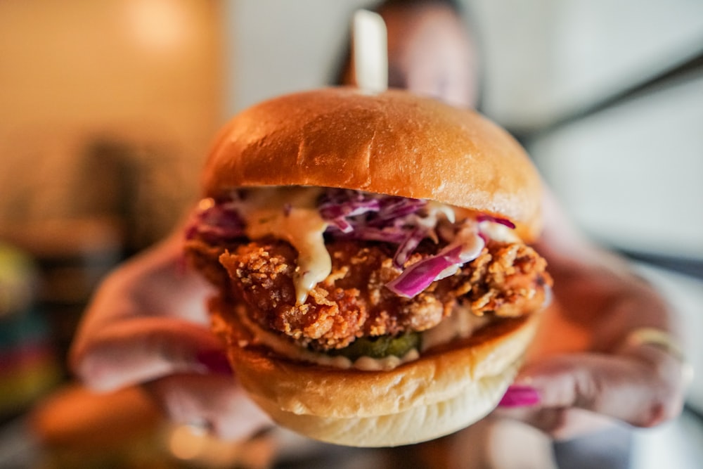 selective focus photography of person holding burger