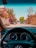 A view from the driver's seat inside a car, showing a residential street lined with walls and flowering trees, including palm trees and bougainvillea. The dashboard and steering wheel are visible in the foreground, while several parked cars and a bright sky can be seen outside.