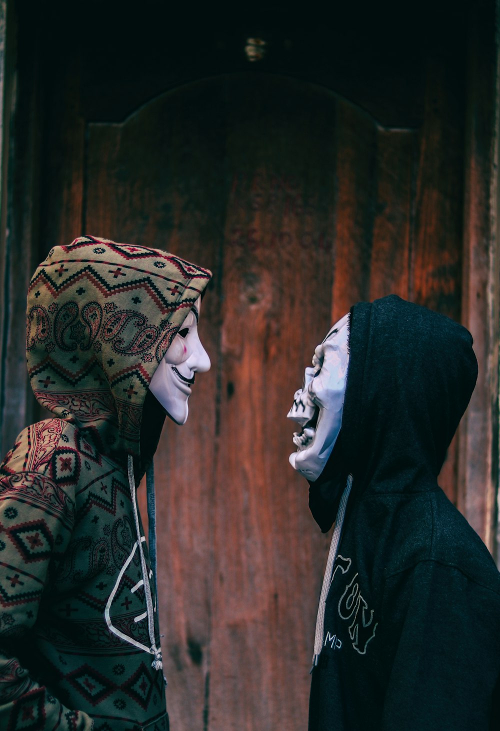 two person's facing each other near brown wooden wall