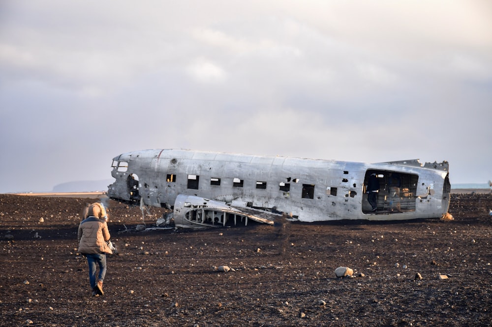 person walking towards abandoned plane during daytime