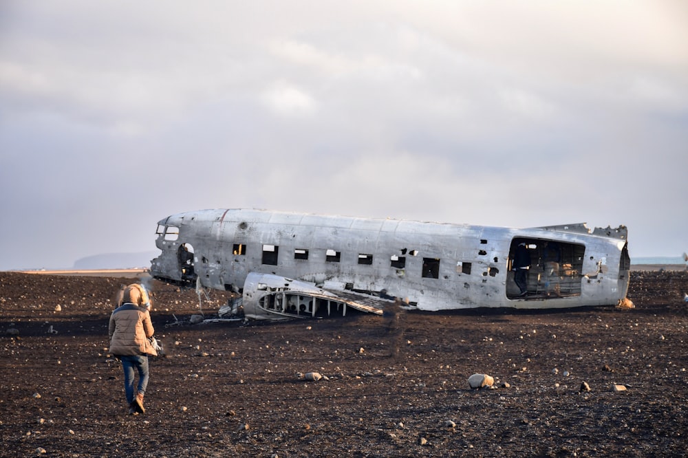 personne marchant vers un avion abandonné pendant la journée