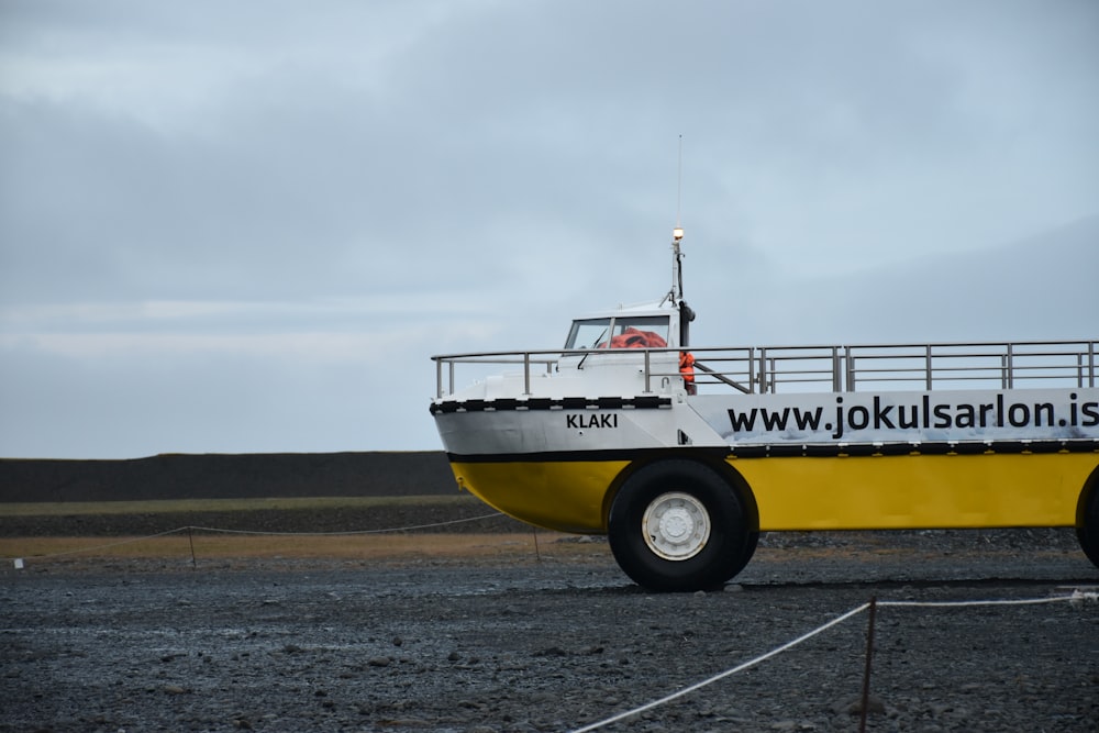 weißes und gelbes Schiffsfahrzeug tagsüber auf dem Feld