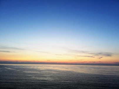 A serene ocean view from a modern hotel balcony at sunset.