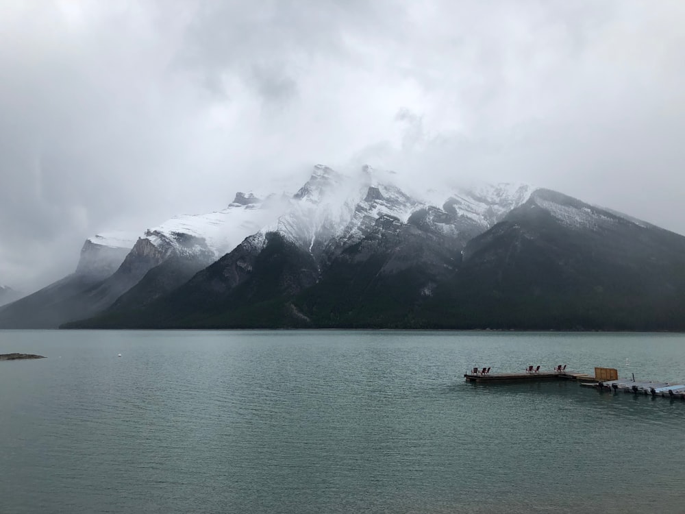 snow covered mountain near dock