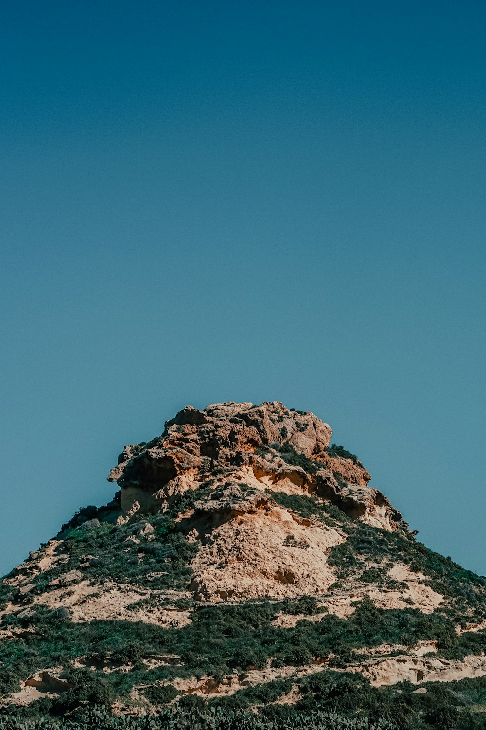 low-angle photography of mountain under calm blue sky