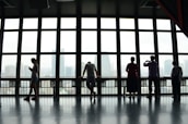 five people standing in front of window