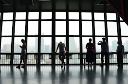 five people standing in front of window