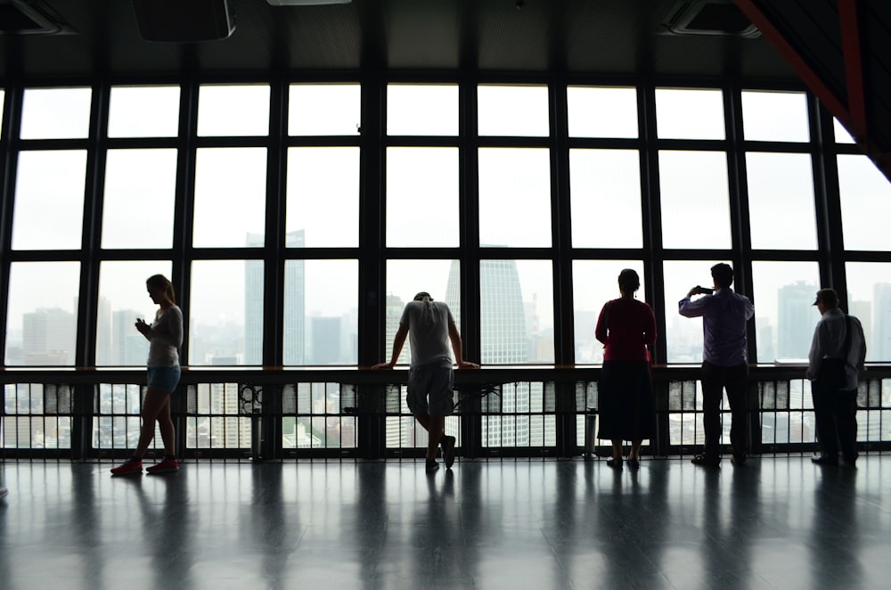 five people standing in front of window