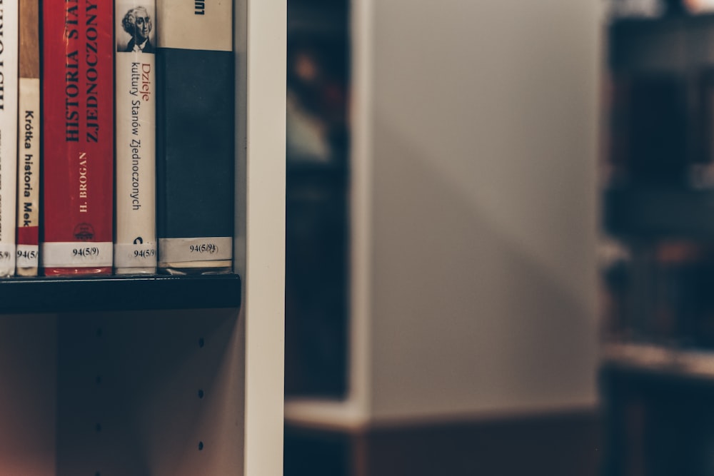 assorted-title books on white shelf