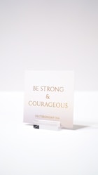 white paper with be strong and courageous printed text
