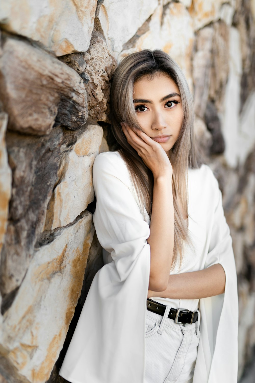 woman leaning on rock wall