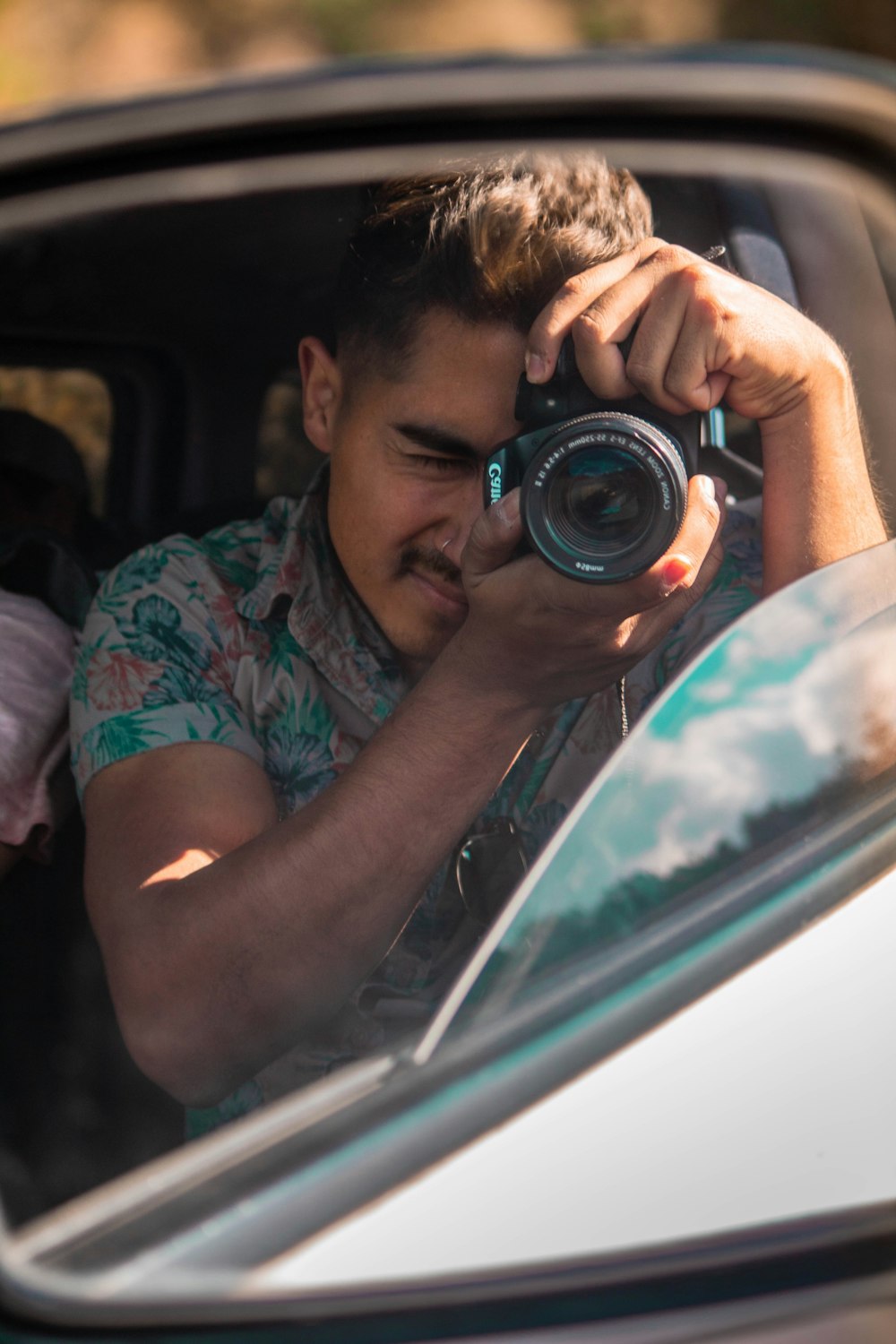 man holding camera inside vehicle