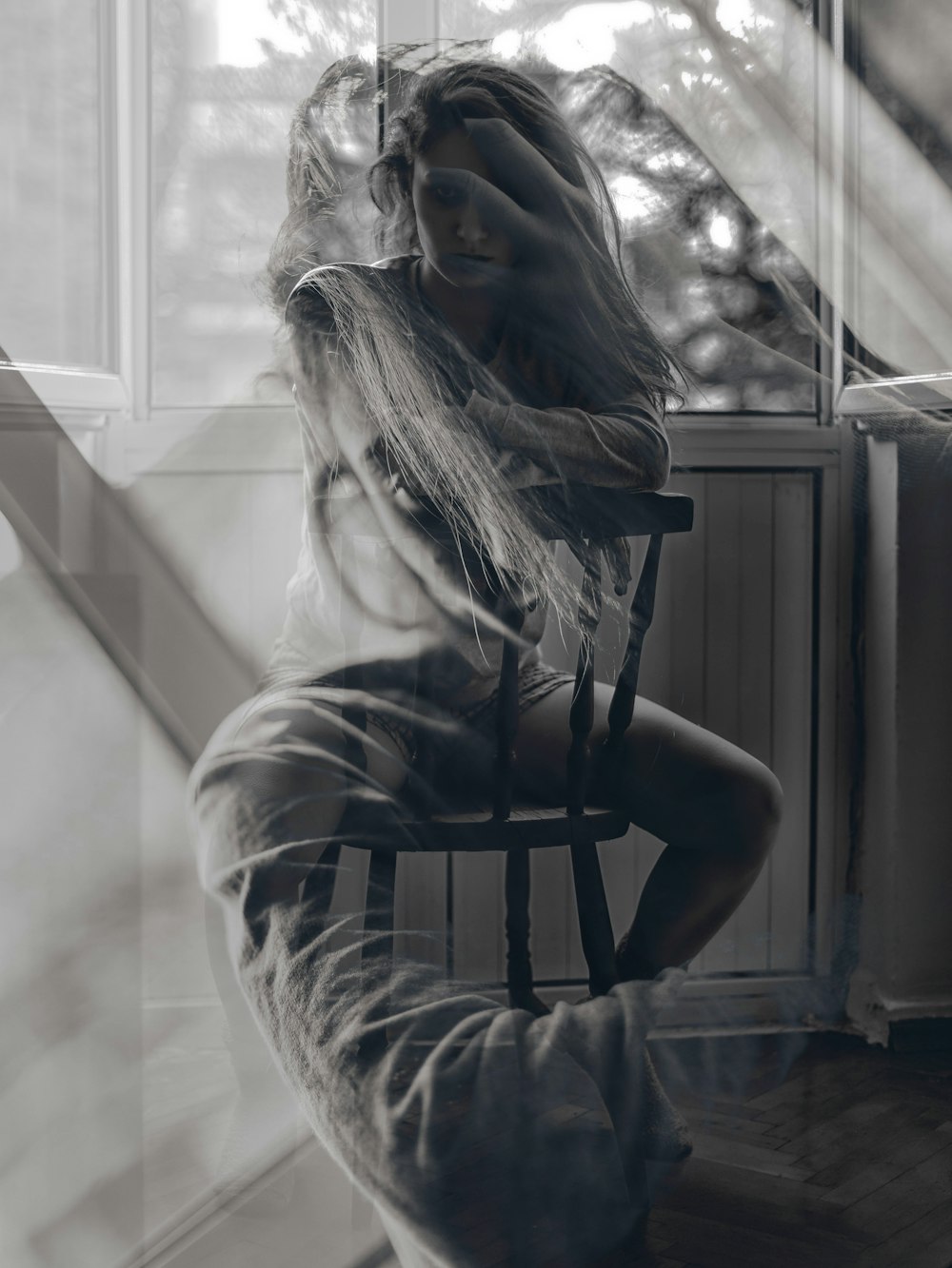 grayscale photography of woman sitting on windsor chair