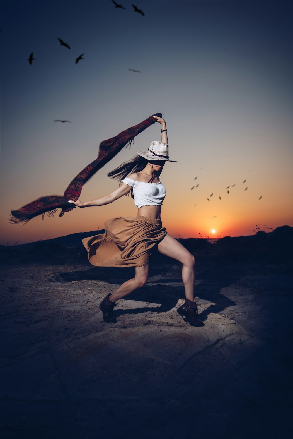 woman posing while holding red and black scarf during sunset