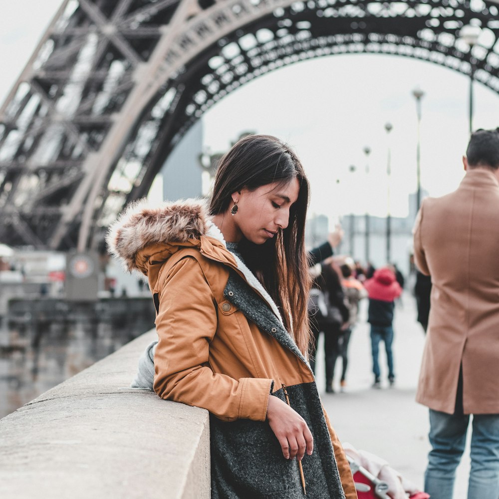 woman leaning against wall near Eiffel Tower