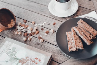 A rustic wooden table displaying fresh bread, colorful local fruits, artisanal cheeses, and a steaming cup of coffee.