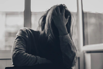 grayscale photography of person covering face