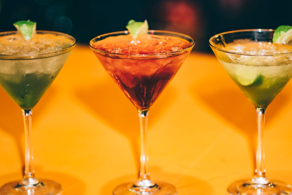 three assorted cocktails in martini glasses