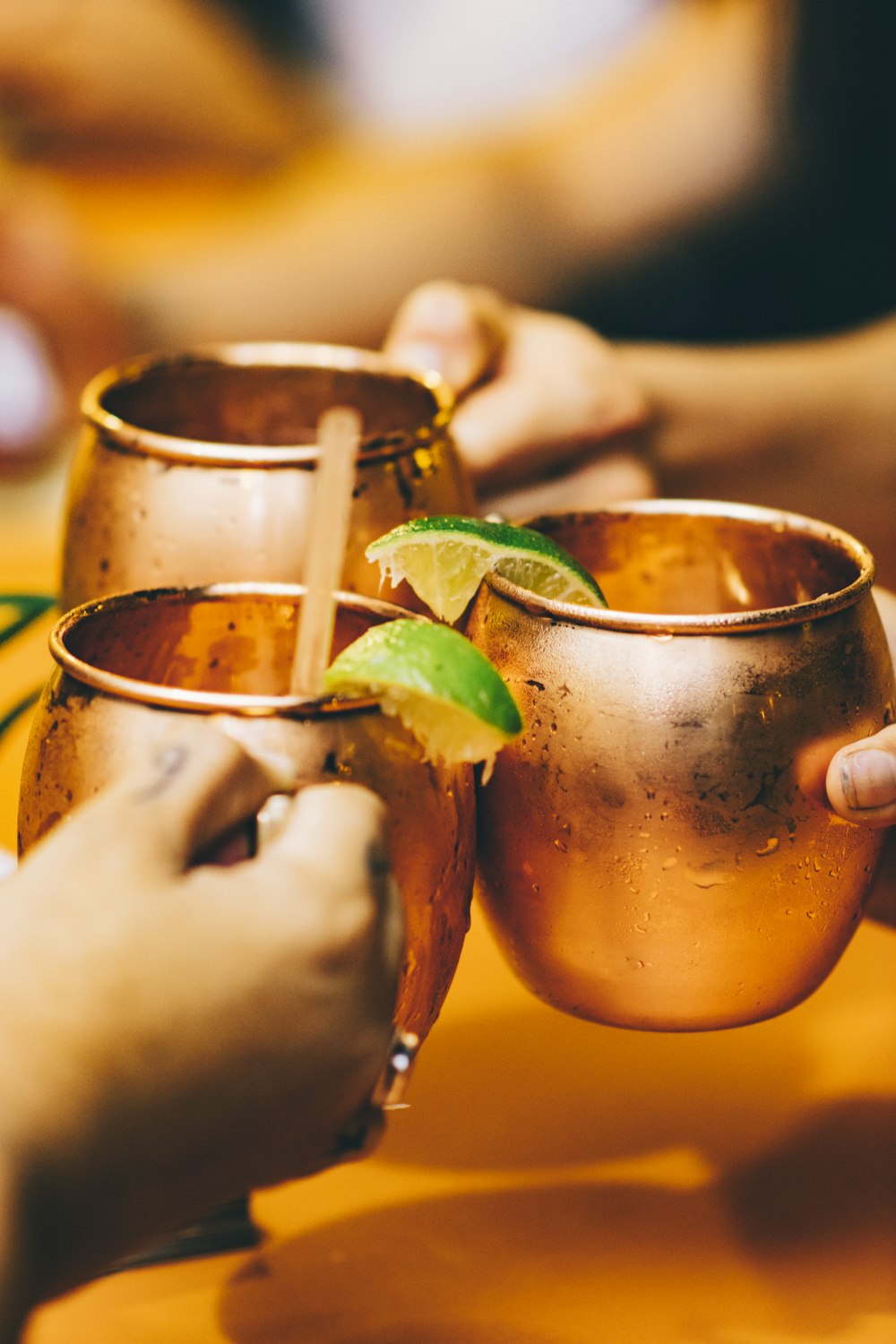 three person holding mugs with lemon juice on selective focus photography