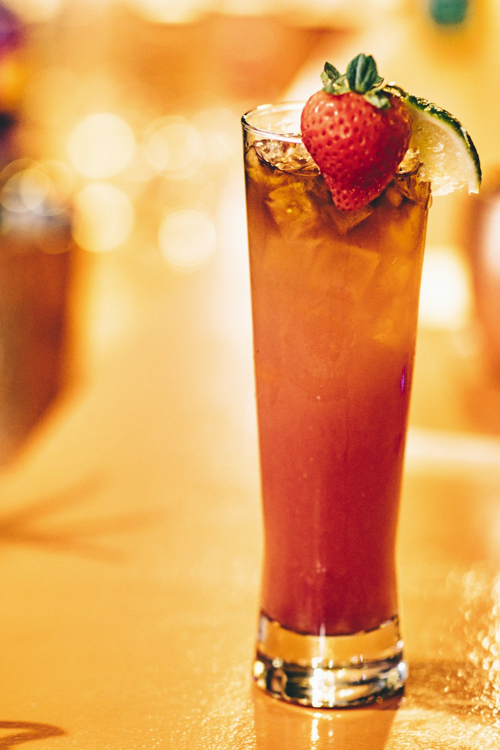 strawberry drink on glass on top of brown table