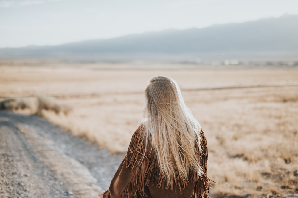 woman walking on gray sand