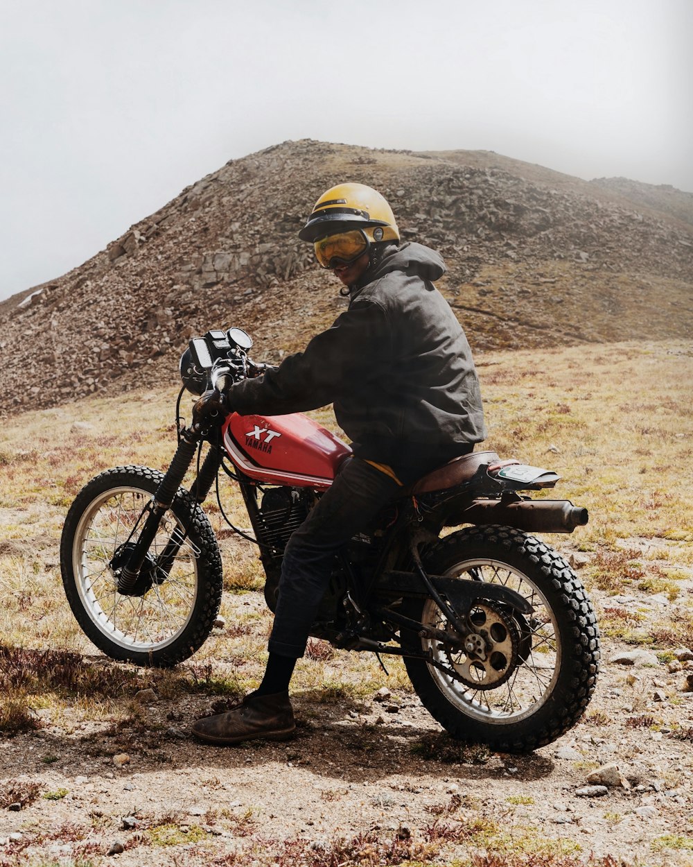 man in gray jacket riding dirt bike