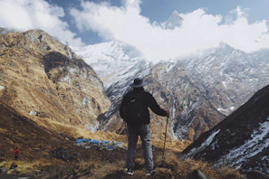 An outdoor scene with a hiker holding a Victorinox knife while admiring a mountain view
