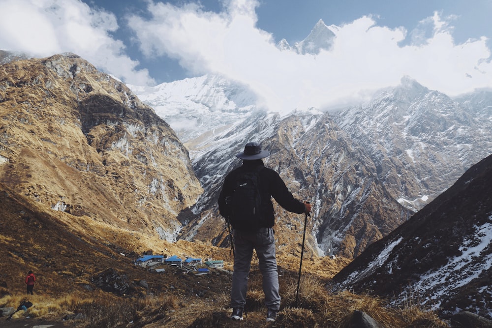 man standing on mountain holding can e