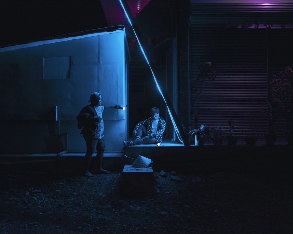 two people outside buildings at night