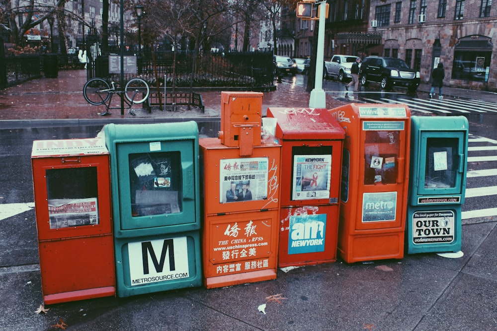 six assorted-color newspaper machines