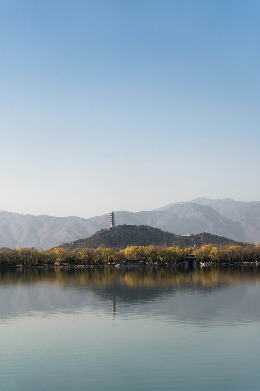 lighthouse on island near mountain range