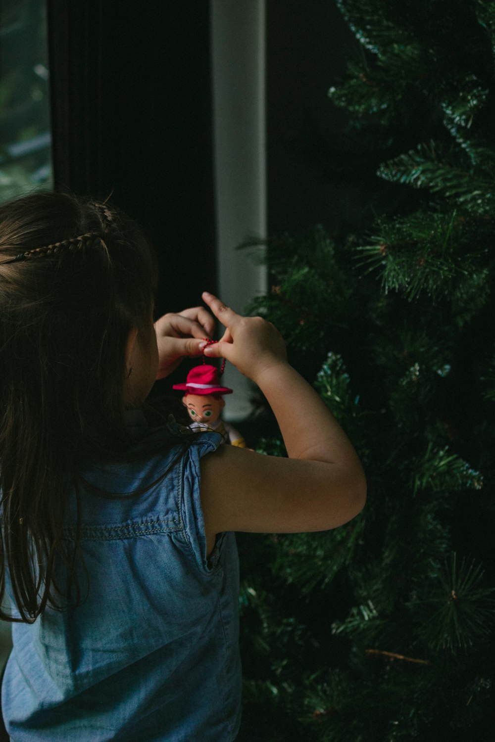 Mädchen steht vor Weihnachtsbaum