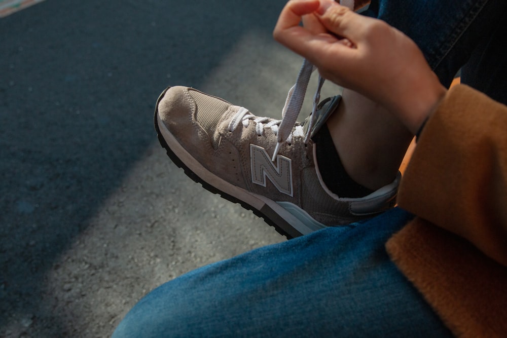 person tying New Balance shoe