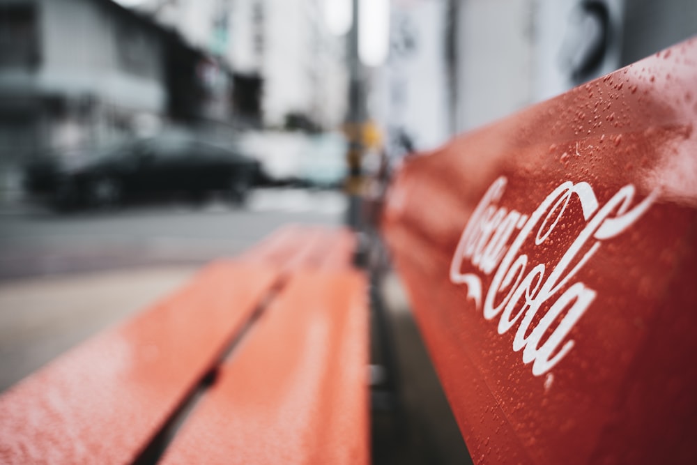 Photographie à mise au point peu profonde d’un banc en bois rouge