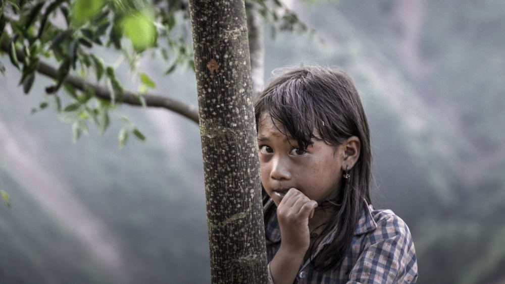 girl hiding behind the tree