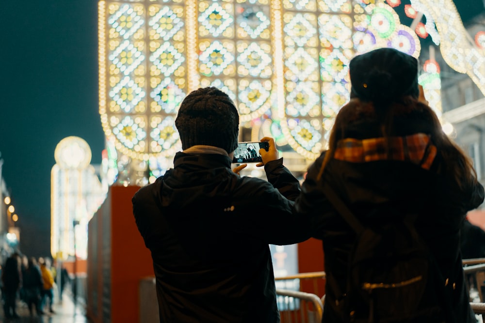 man standing holding phone on selective focus photography