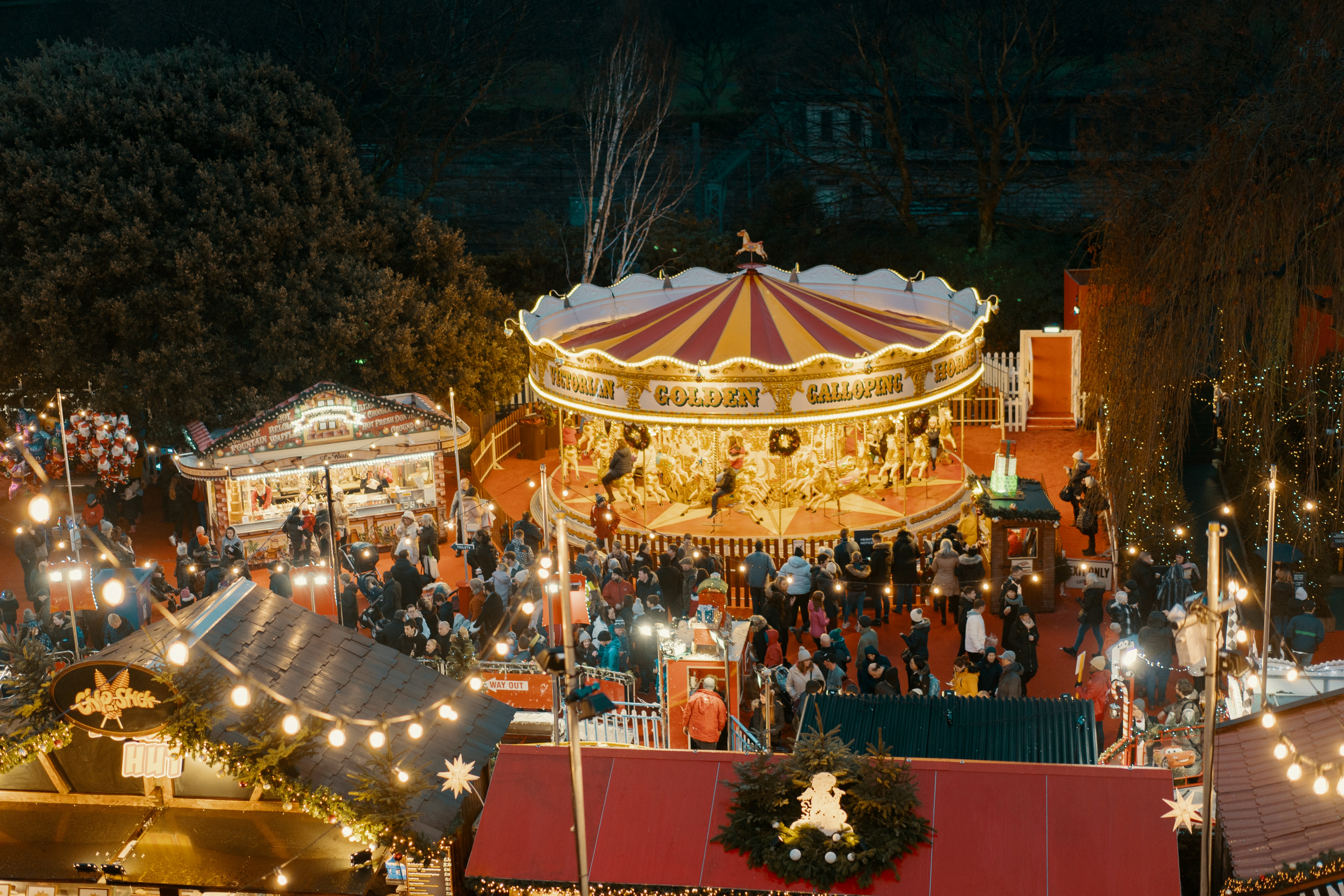 people standing near merry-go-round on amusement park during night time, Christmas in Edinburgh